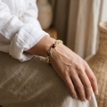 “Ivana” Multicolor Baltic Amber Bracelet in Sterling Silver worn on a model’s wrist, shown in a close-up view.