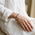 “Bajena” Baltic Honey Amber Bracelet in Sterling Silver worn on a model’s wrist, shown in a close-up view.