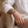 “Alison” Baltic Honey Amber Bracelet in Sterling Silver worn on a model’s wrist, shown in a close-up view.