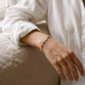 “Aster” Multicolor Baltic Amber Bracelet in Sterling Silver worn on a model’s wrist, shown in a close-up view.