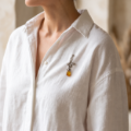 “Rose” Baltic Amber Brooch in Sterling Silver worn on a garment, shown in a close-up view.