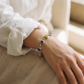 Multicolor Baltic Amber Bracelet in Sterling Silver worn on a model’s wrist, shown in a close-up view.