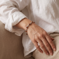 “Cats” Baltic Honey Amber Bracelet in Sterling Silver worn on a model’s wrist, shown in a close-up view.