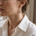 “Spider on the Web” Baltic Honey Amber Drop Earrings in Sterling Silver worn on a model, shown in a close-up side view.