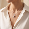 Baltic Honey Amber Squirrel Pendant in Sterling Silver worn on a chain, shown in a close-up view of the neck and collarbone.