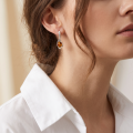 Baltic Honey Amber Earrings in Sterling Silver worn on a model, shown in a close-up side view.