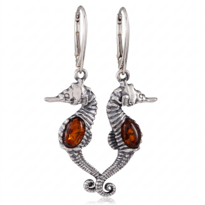 “Seahorses” Baltic Amber Drop Earrings in Sterling Silver worn by a model, shown in a close-up view of the ear.“Seahorses” Baltic Amber Drop Earrings in Sterling Silver worn by a model, shown in a close-up view of the ear.